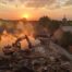 A dynamic, wide-angle shot of a backyard in an affluent Oklahoma City neighborhood at sunset. On the right side, the remnants of a cracked, empty in-ground concrete pool are visible. On the left side, an F5 Demolition excavator (with a visible logo) is actively engaged in compacting layers of fresh, clean fill dirt, with a dust cloud minimized by a water spray. The contrast should show the "before" (broken pool) and "after" (reclaimed land). The overall tone is professional, transformative, and hopeful.